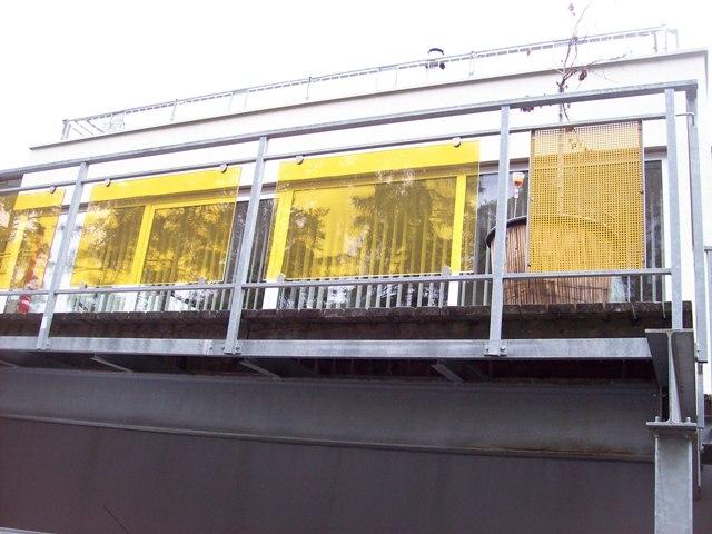Geländer aus Stahl verzinkt mit gelben Lochblech Elementen + Elementen aus Gelb getönten Glas