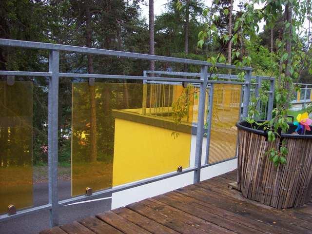 Geländer aus Stahl verzinkt mit gelben Lochblech Elementen + Elementen aus Gelb getönten Glas