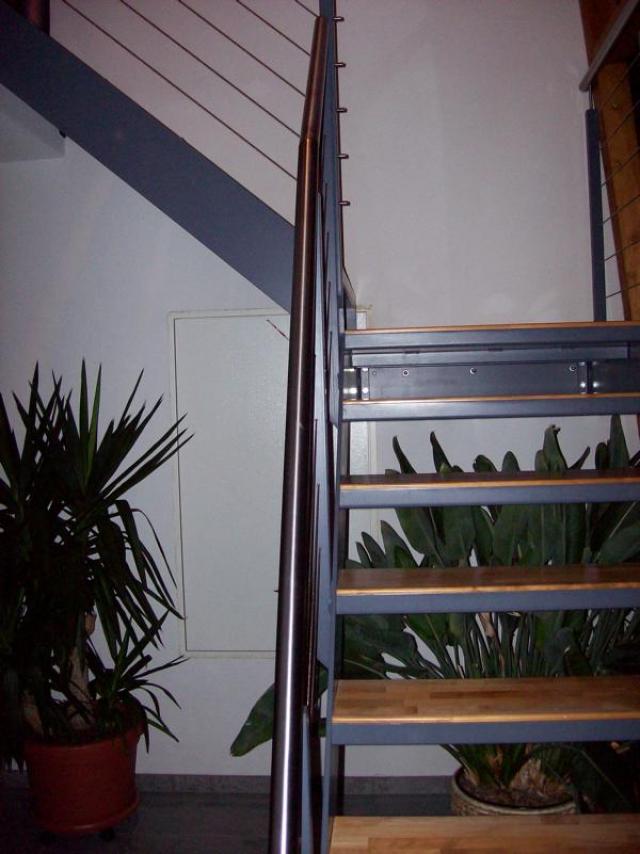 Innenstahltreppe mit HolztrittenGeländer beschichtet mit Niroseilfüllung und Nirohandlauf